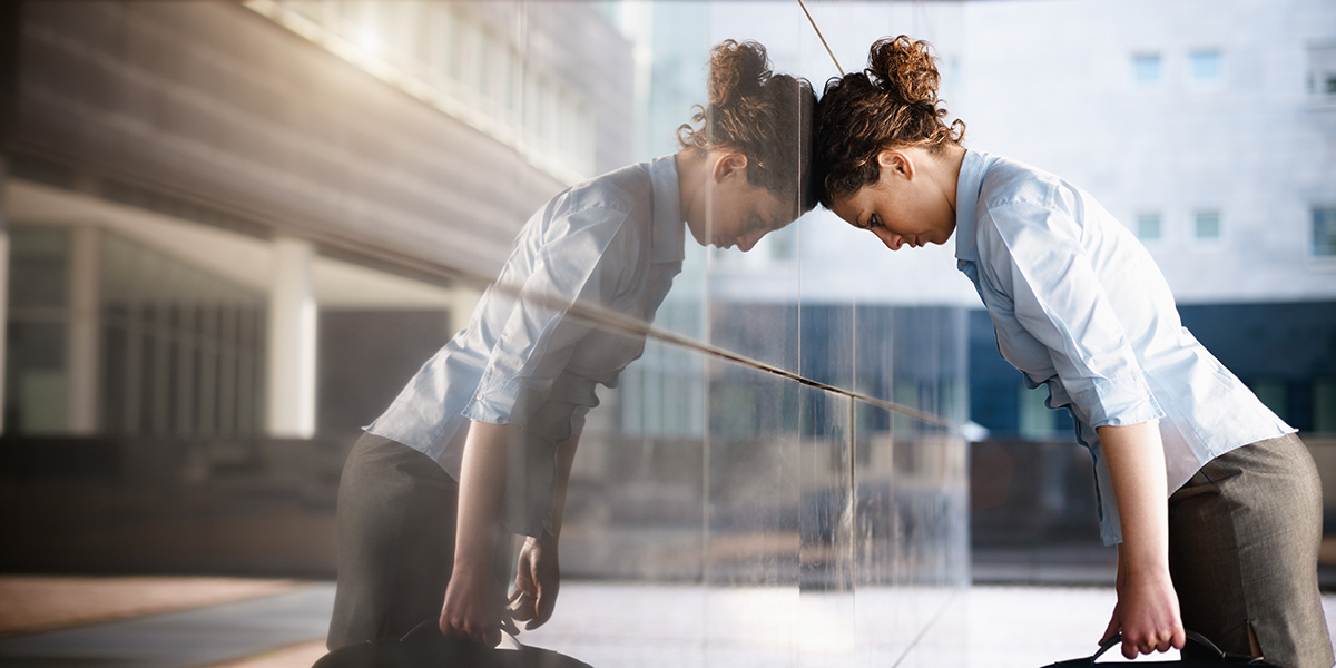 mid adult italian woman banging her head against a wall outside office building. Horizontal shape, copy space