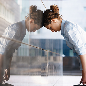 mid adult italian woman banging her head against a wall outside office building. Horizontal shape, copy space